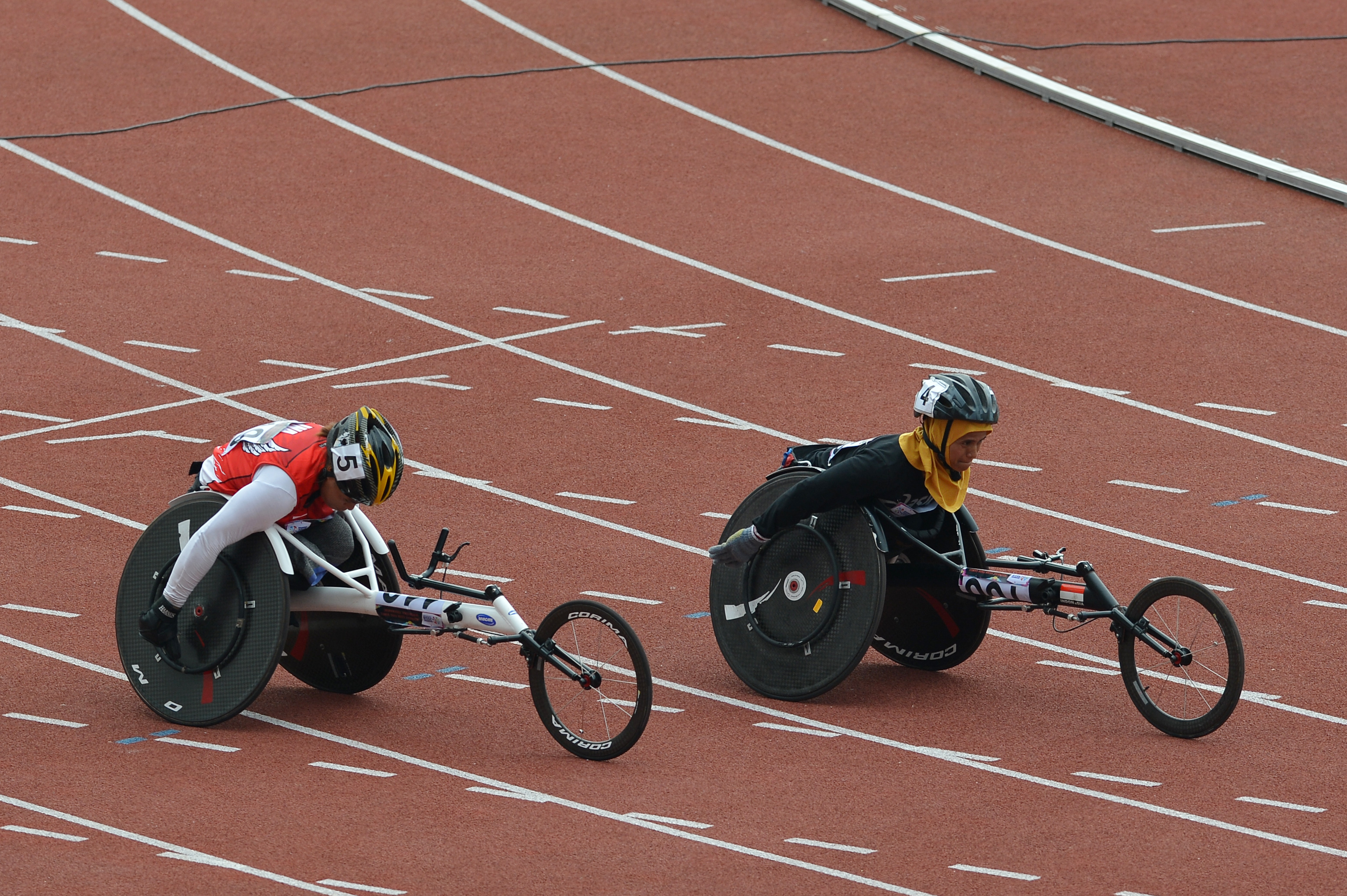 Pelari difabel Indonesia Maria Goreti Samiyati (kiri) beradu cepat dengan Mulyani ketika bertanding nomor 100 meter putri kategori T54 pada Indonesia Para Games Invitational Tournament di Stadion Madya Kawasan Gelora Bung Karno, Senayan, Jakarta, Minggu (1