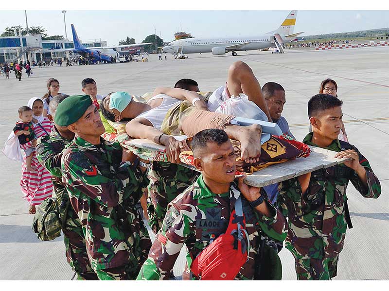 EVAKUASI KORBAN: Warga korban gempa dan tsunami ditandu prajurit TNI saat akan menaiki pesawat Hercules di Bandara Mutiara SIS Al-Jufri, Palu, Sulawesi Tengah, kemarin. TNI mengoperasikan Hercules untuk mengevakuasi ratusan pengungsi gempa dan tsunami Palu