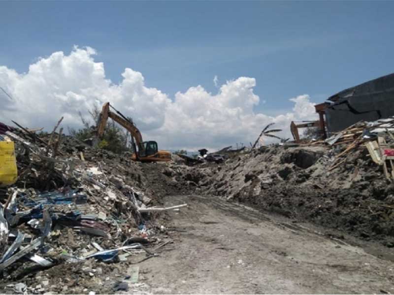 Sebuah ekskavator membongkar reruntuhan bangunan untuk menemukan jenazah korban terjangan bencana gempa dan tsunami di Palu, Selasa, 2 Oktober 2018