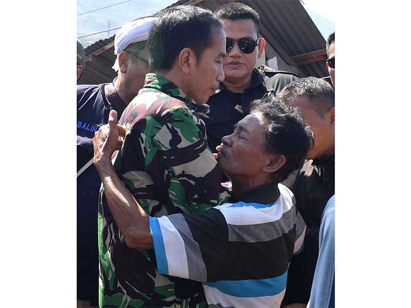 PRESIDEN TINJAU LOKASI GEMPA PALU: Presiden Joko Widodo (kiri) dipeluk oleh warga saat meninjau korban gempa bumi dan tsunami di Palu, Sulawesi Tengah, Minggu (30/9). Presiden memerintahkan jajarannya untuk memprioritaskan evakuasi korban sebagai langkah p