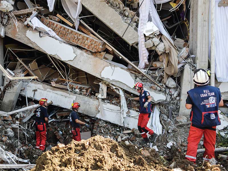 BANTU MENCARI KORBAN GEMPA: Personel Pemadam Kebakaran Darurat Internasional Prancis membantu mencari korban gempa dan tsunami yang terjebak di reruntuhan Hotel Mercure di Palu, Sulawesi Tengah, kemarin. Bantuan dari luar negeri mulai mengalir, di antarany