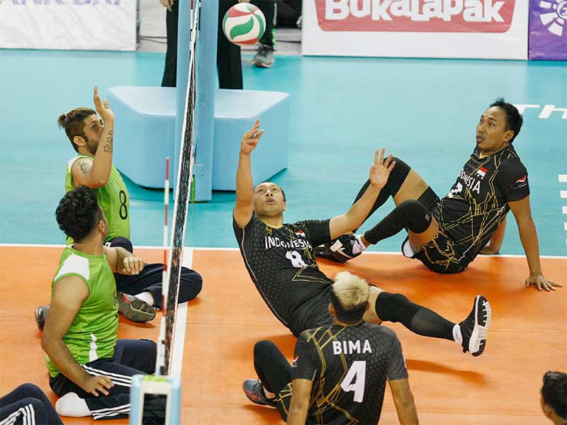 Atlet bola voli duduk Indonesia Murdiyan (8) berusaha mengembalikan bola ke arah pebola voli duduk Irak saat pertandingan Grup A bola voli duduk Asian Para Games 2018 di Tennis Indoor, Komplek GBK, Senayan, Jakarta, Senin (8/10). 