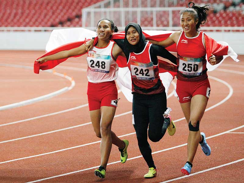 SAPU BERSIH MEDALI: Sprinter Indonesia Putri Aulia (kanan), Ni Made Arianti Putri (kiri), dan Endang Sari Sitorus merayakan kemenangan seusai fi nal lari 100 meter putri T13 di Stadion Utama GBK, Senayan, Jakarta, kemarin. Putri Aulia merebut medali emas, 