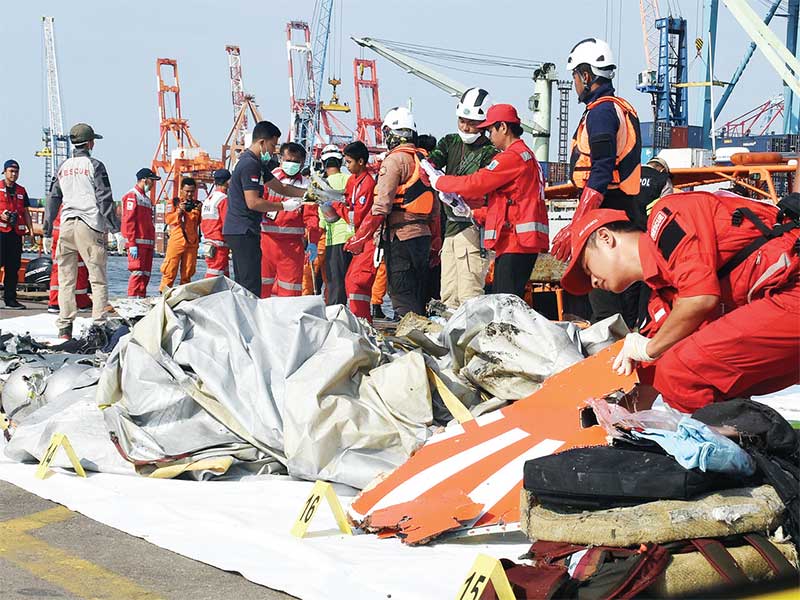 KUMPULKAN SERPIHAN PESAWAT LION AIR JT610: Petugas Basarnas mengumpulkan serpihan badan pesawat Lion Air JT610 setelah mengevakuasi dari laut, di Pelabuhan Tanjung Priok, Jakarta, kemarin. Pesawat Lion Air yang membawa penumpang dan kru kabin sebanyak 189 
