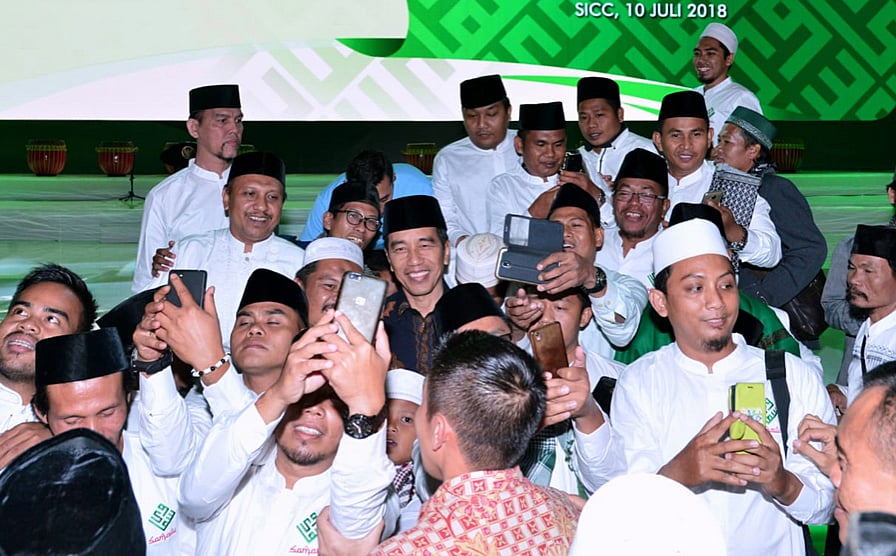 Presiden Joko Widodo dikerumuni ulama muda yang ingin berswafoto dengan dirinya saat Halalbihalal dan Silaturahim Nasional Solidaritas Ulama Muda Jokowi (Samawi) di Sentul, Babakan Madang, Kabupaten Bogor, Jabar, Juli lalu.