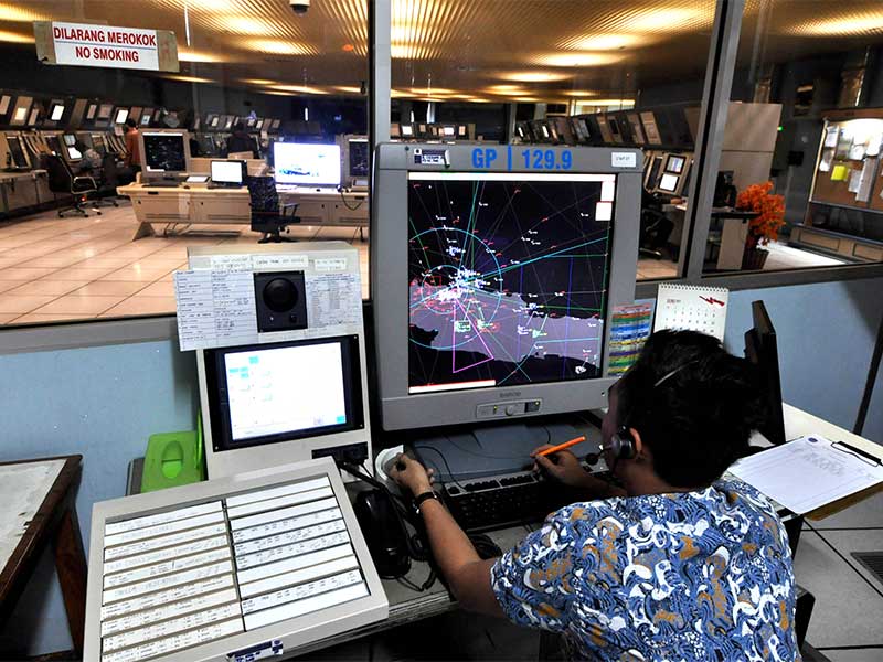 Petugas AirNav Bandar Udara Soekarno Hatta memantau dan mengatur pergerakan pesawat di udara, Tangerang, Banten, Jumat (19/6). 