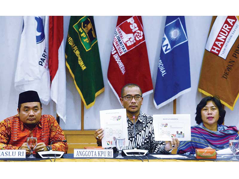 PENETAPAN DESAIN ALAT PERAGA KAMPANYE: Komisioner KPU Hasyim Asy’ari (tengah) bersama Kabiro Teknik dan Humas Nur Syarifah dan komisioner Bawaslu M Afi fuddin (kiri) menunjukkan desain baliho pasangan calon presiden nomor urut 01 saat rapat pembahasan peny