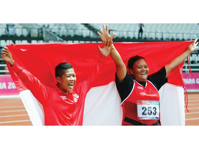 RAYAKAN KEMENANGAN: Atlet tolak peluru Indonesia Suparniyati (kanan) dan Tiwa merayakan kemenangan seusai merebut medali emas dan perunggu nomor tolak peluru putri F20 Asian Para Games 2018 di Stadion Utama GBK, Senayan, Jakarta, kemarin.