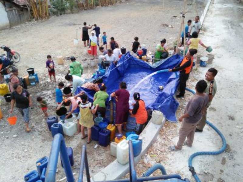 Warga mengumpulkan air