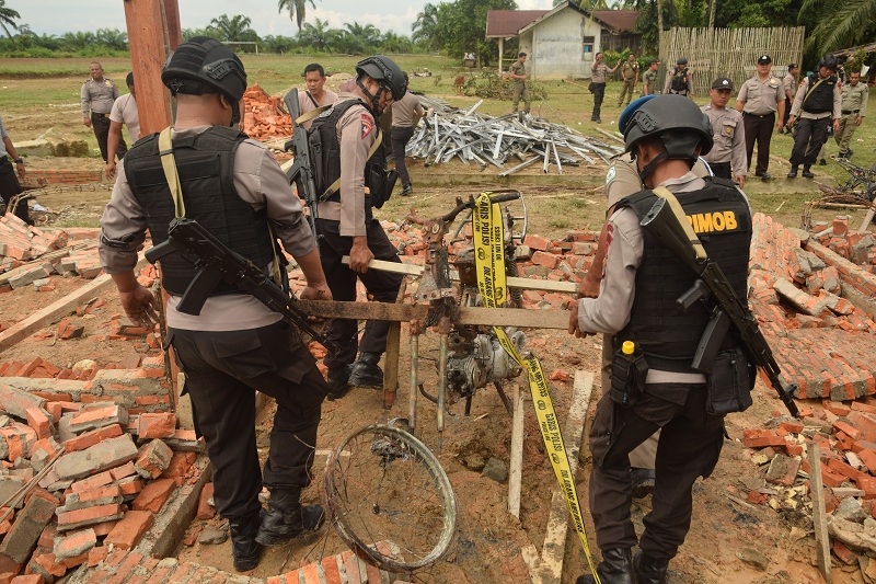 PASCAPEMBAKARAN POLSEK BENDAHARA: Personel kepolisian membersihkan puing bangunan dan kendaraan dinas yang dibakar oleh massa di Mapolsek Bendahara, Aceh Tamiang