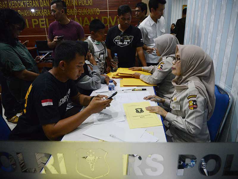 Petugas Posko DVI RS Polri melayan keluarga korban pesawat Lion Air JT610 yang datang untuk menyerahkan berkas milik korban di RS Polri, Jakarta, Senin (29/10/2018).