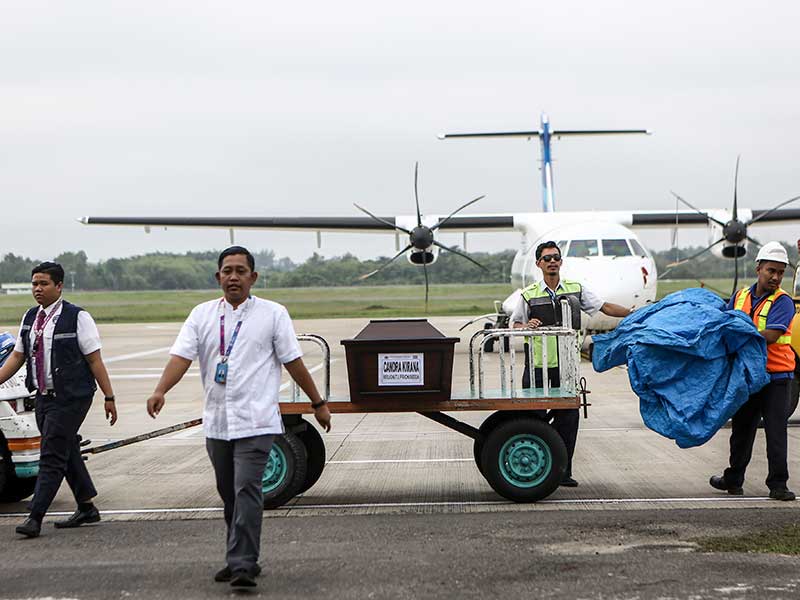 : Petugas cargo membawa peti Jenazah korban jatuhnya pesawat Lion Air JT 610 Chandra Kirana saat tiba diterminal cargo Bandara Sultan Mahmud Baddarudin (SMB) II Palembang, Sumatera Selatan, Sabtu (3/11/2018)