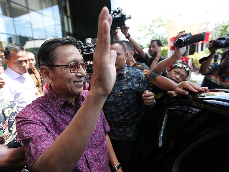 Mantan Wakil Presiden Boediono melambaikan tangan ke arah jurnalis yang mengajukan pertanyaan, seusai menjalani pemeriksaan di Gedung KPK, Jakarta, Kamis (15/11/2018)
