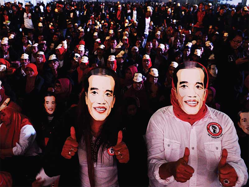 RELAWAN JOKOWI: Sukarelawan berpose menggunakan topeng bergambar wajah calon presiden nomor urut 01 Joko Widodo saat acara Jokowi Lantik 7.000 ‘Jokowi’ di kawasan industri Sentul, Babakan Madang, Kabupaten Bogor, kemarin. Acara yang diselenggarakan oleh Po