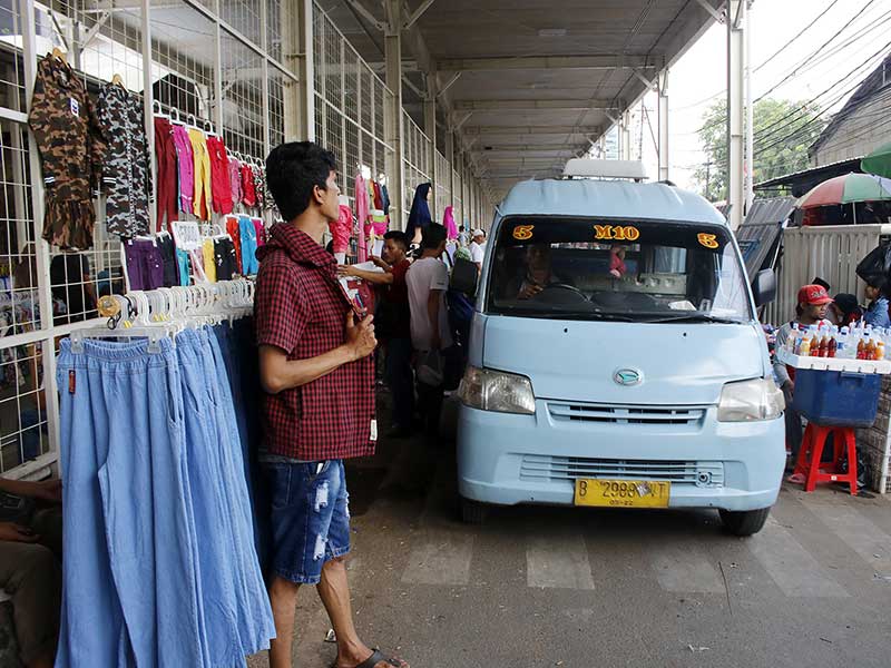 Sebuah angkot berjalan pelan di antara para PKL yang berjualan di jalan bawah kolong jembatan multifungsi atau skybridge di Tanah Abang, Jakarta Pusat, Selasa (13/11/2018)
