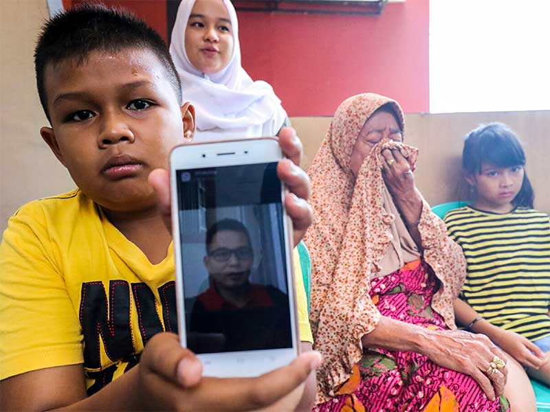 KORBAN JATUHNYA PESAWAT LION AIR JT 610: Ketiga anak korban kecvelakaan Lion Air JT 610 Eryanto, bersama dengan neneknya memperlihatkan foto ayahnya di Kantor pusat PT Timah Tbk, Pangkalpinang, Kepulauan Bangka Belitung, Kamis (1/11/2018).