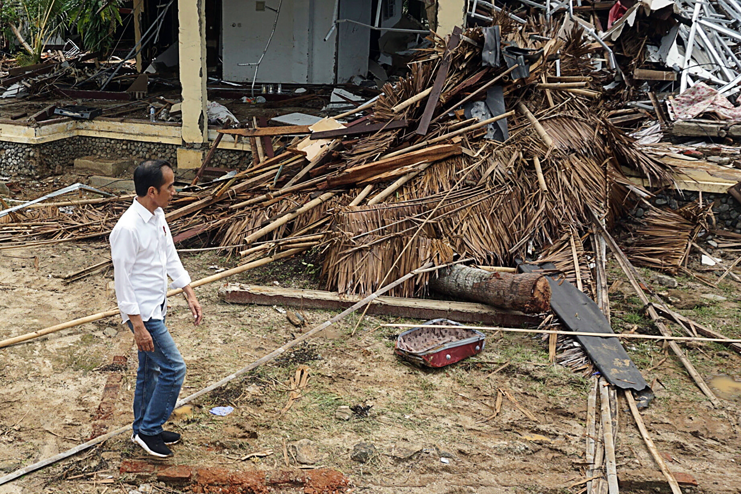 Presiden Joko Widodo mengamati bangunan Hotel Mutiara Carita yang rusak akibat tsunami di Kabupaten Pandeglang, Banten pada Senin (24/12). 