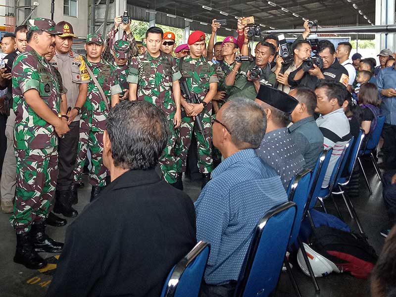 Panglima TNI Marsekal Hadi Tjahjanto (kiri) berbincang dengan keluarga korban penembakan kelompok kriminal separatis bersenjata (KKSB) saat serah terima jenazah di hanggar Avco Bandara Moses Kilangin Timika, Mimika, Papua, Jumat (7/12/2018)