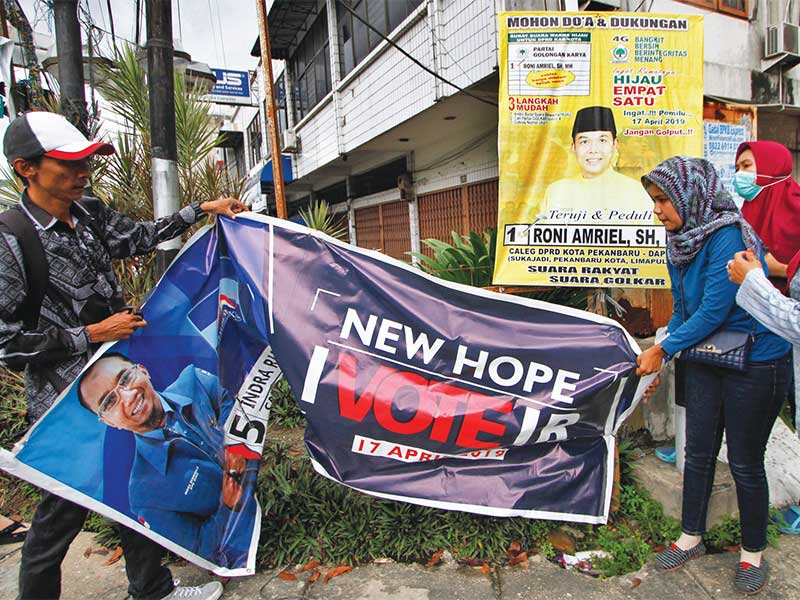 PENERTIBAN APK PEMILU 2019: Petugas Panwaslu Kota Pekanbaru mencopot alat peraga kampanye (APK) Pemilu 2019 yang melanggar aturan di Kota Pekanbaru, Jumat (7/12). Pencopotan APK tersebut sesuai peraturan Komisi Pemilihan Umum (PKPU) yang melarang pemasanga