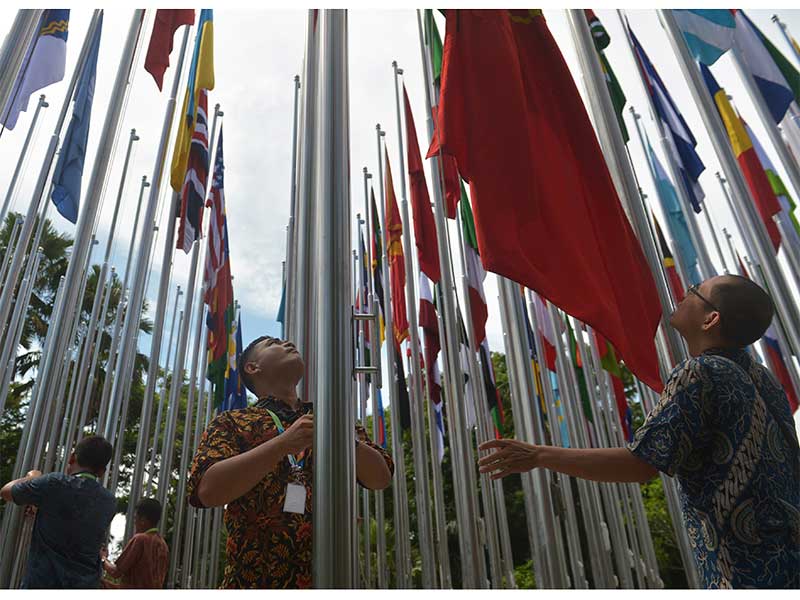 Pekerja memasang bendera negara peserta Bali Democracy Forum 2018 menjelang dimulainya pertemuan tersebut di Nusa Dua, Bali, Rabu (5/12/2018).