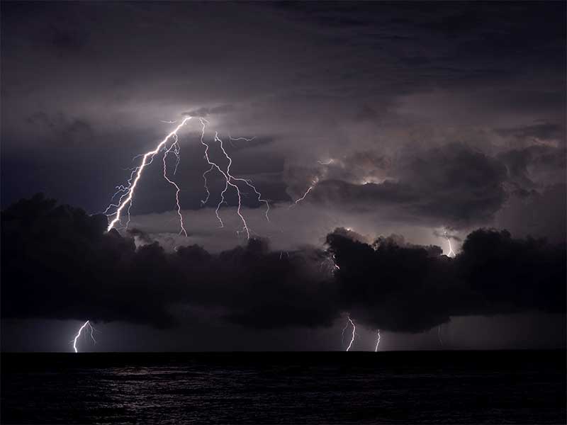 Kilatan petir menyambar di sekitar Gunung Anak Krakatau dipantau dari pantai Anyer, Serang, Banten, Kamis (27/12) malam.
