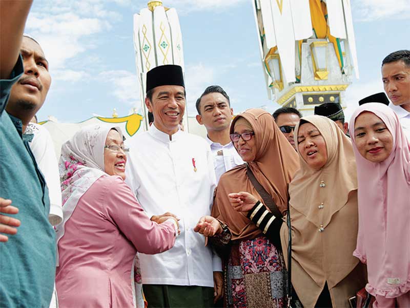 Presiden Joko Widodo melayani permintaan masyarakat untuk berfoto bersama seusai menunaikan ibadah salat Jumat di Masjid Baiturrahman, Banda Aceh, Jumat (14/12/2018)