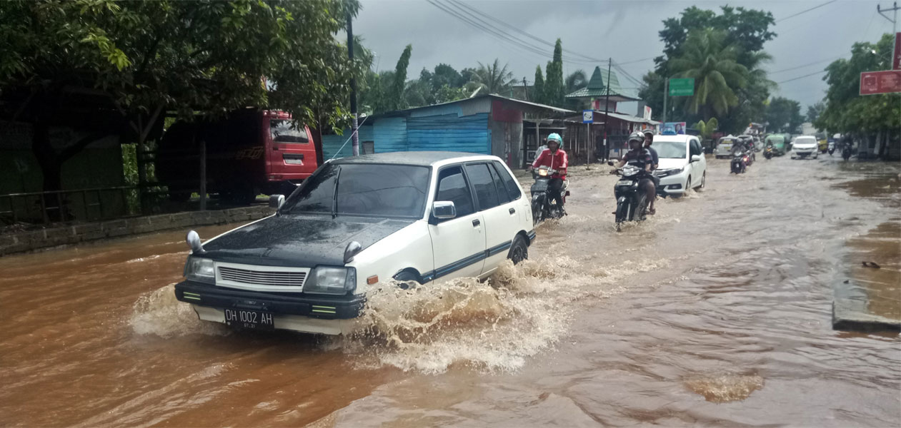 Kendaraan melintas di genangan air di Jalan WJ Lalamentik, Kupang, Nusa Tenggara Timur, Rabu (30/1). Hujan lebat yang mengguyur Kota Kupang pada Rabu pagi mengakibatkan genangan air di sejumlah titik jalan.