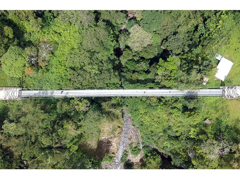 Foto udara warga melintas di atas jembatan gantung yang dibangun Kementerian PUPR di Nagari Guguak Sarojo, IV Koto, Agam, Sumatera Barat, Kamis (27/12/2018). 