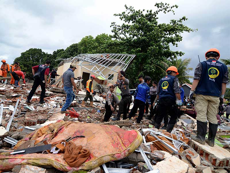 Tim dan relawan mengevakuasi dugaan korban yang tertimbun bangunan di Hotel Stephani, Anyer, Banten, Senin (24/12). 