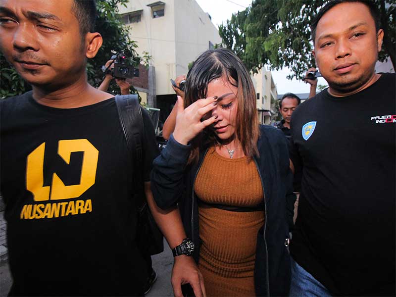 Artis berinisial AS (tengah) berjalan keluar usai menjalani pemeriksaan terkait kasus prostitusi daring di Gedung Subdit Siber Ditreskrimsus Polda Jawa Timur, Surabaya, Jawa Timur, Minggu (6/1/2019). 