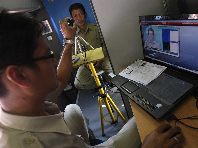 Seorang pegawai yang bekerja di Balai Kota DKI Jakarta melakukan pemotretan untuk pembuatan KTP di Pelayanan Keliling KTP dan Akta Kelahiran di Lapangan Irti Monas, Jakarta, Kamis (10/2).