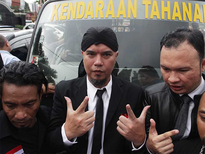 Terdakwa kasus ujaran kebencian Ahmad Dhani (tengah) berpose di depan mobil tahanan usai menjalani sidang pembacaan vonis di Pengadilan Negeri Jakarta Selatan, Jakarta, Senin (28/1).