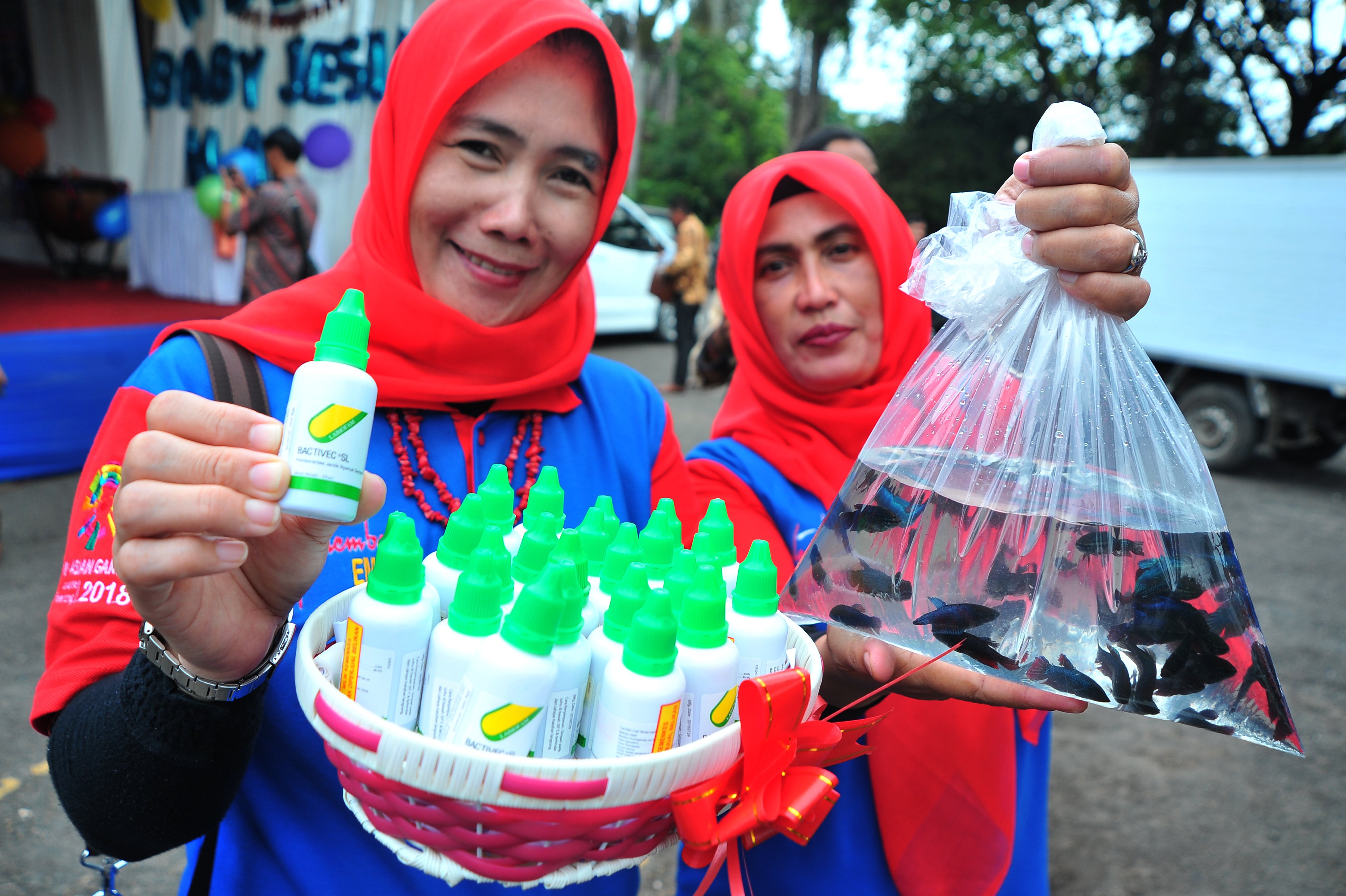 Petugas Juru Pemantau Jentik (Jumantik) menunjukkan dua senjata penangkal jentik DBD berupa cairan pembasmi jentik dan ikan cupang usai pencanangan gerakan satu rumah rumah satu jumantik di halaman rumah dinas wali kota Palembang, Sumsel, beberapa waktu la