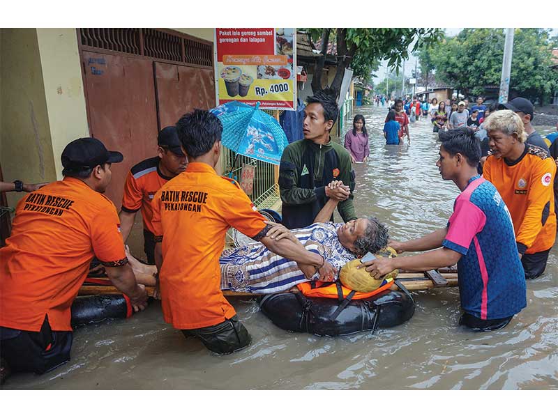 EVAKUASI WARGA YANG SAKIT: Relawan mengevakuasi warga yang sakit di lokasi terdampak banjir di Pekalongan, Jawa Tengah, kemarin. Banjir yang disebabkan curah hujan tinggi tersebut mengakibatkan hampir 90% wilayah Kota Pekalongan terendam dengan kedalaman r