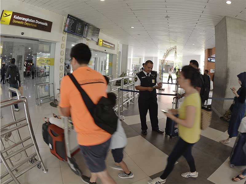 Petugas memeriksa tiket calon penumpang pesawat di Terminal Keberangkatan Domestik Bandara Internasional I Gusti Ngurah Rai, Bali, Jumat (4/1/2019).