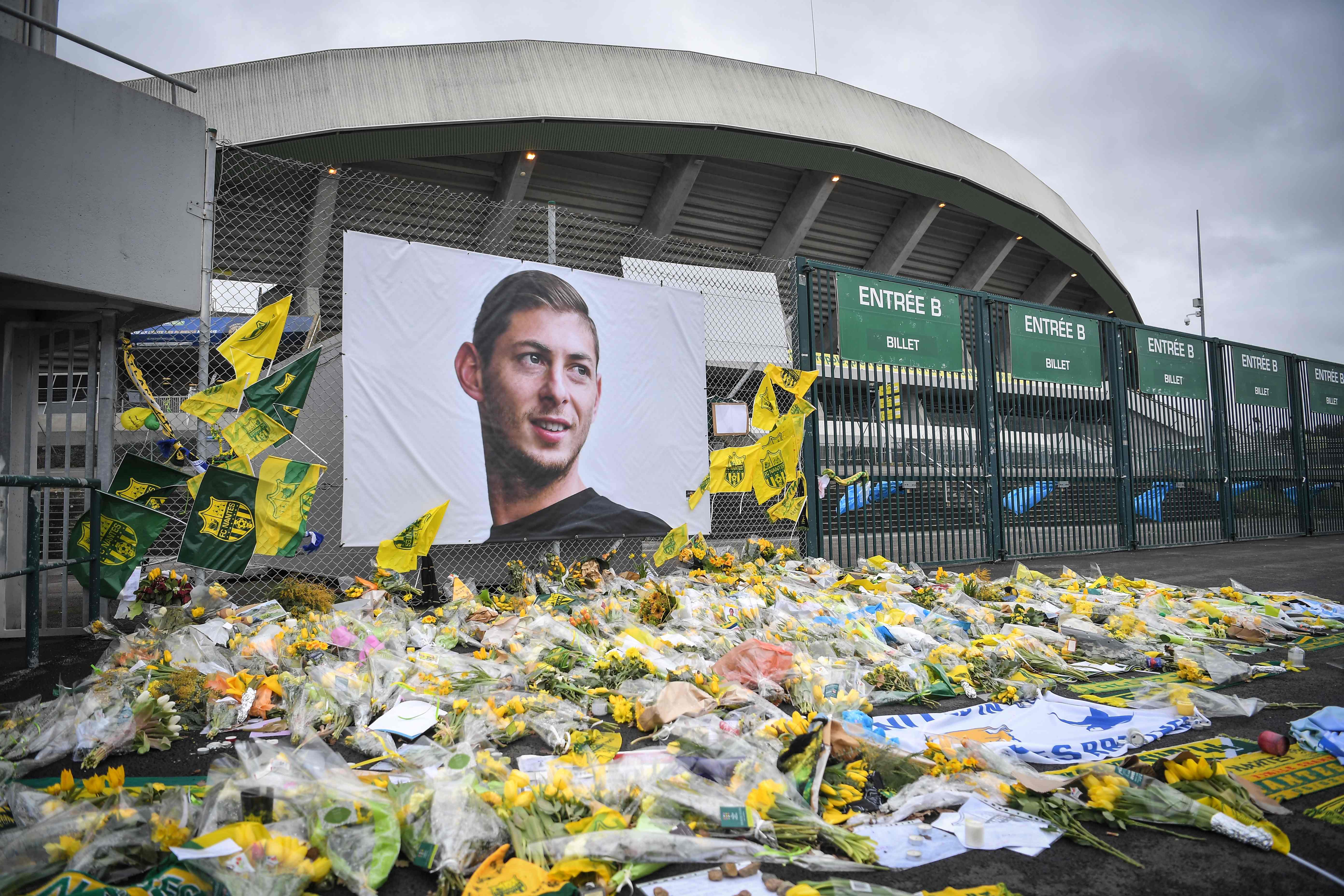 Bunga-bunga kuning dipersembahkan di depan foto pemain depan Argentina Emiliano Sala di stadion Beaujoire di Nantes, pada 8 Februari 2019. - Klub sepakbola FC Nantes mengumumkan pada 8 Februari 2019 bahwa itu akan membekukan jersey nomor 9 sebagai pengharg