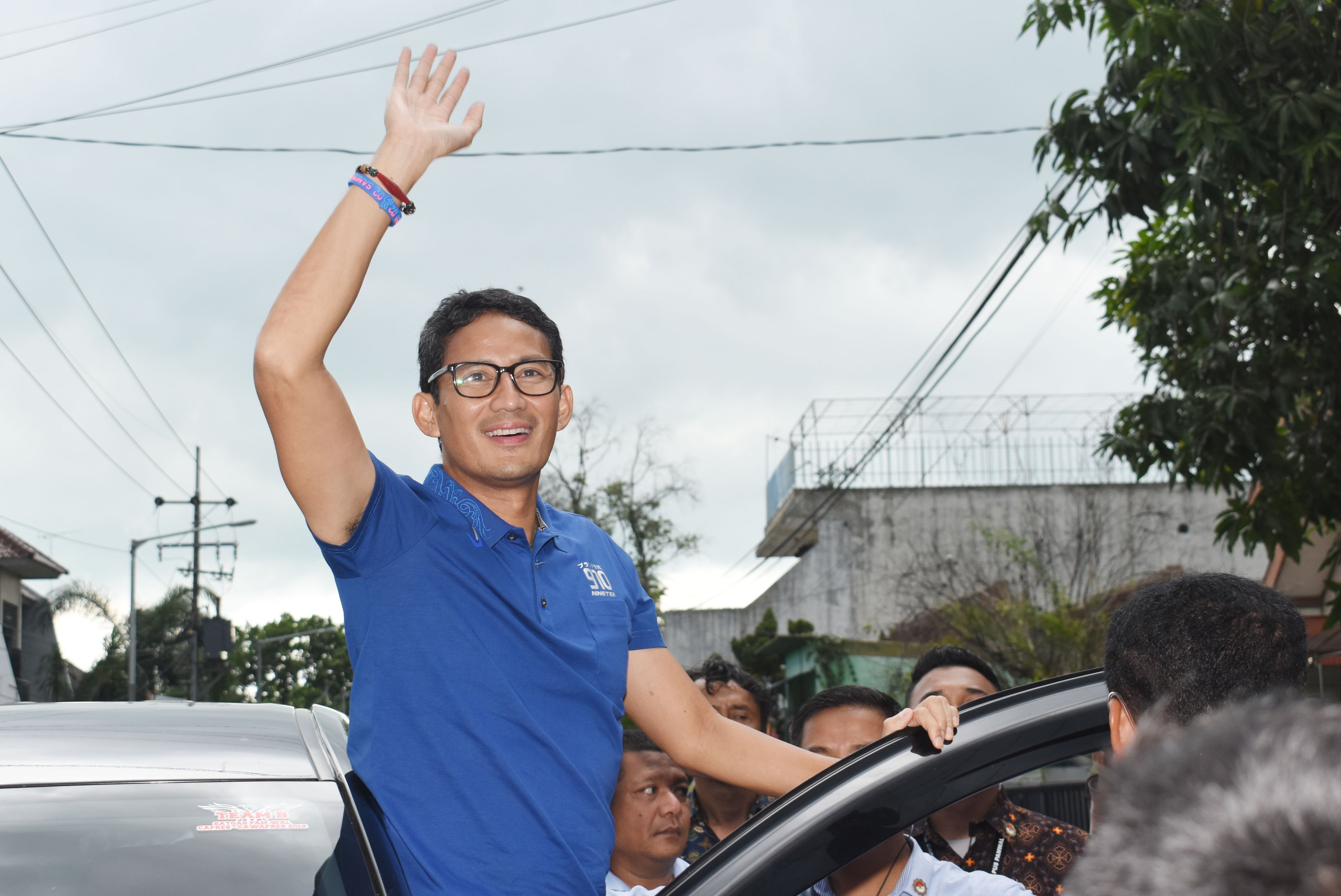 Calon Wakil Presiden (Cawapres) nomor urut 02 Sandiaga Uno dari pintu mobil menyapa pendukungnya di Kota Madiun, Jawa Timur, Rabu (6/2/2019). Sandiaga Uno melakukan serangkaian kegiatan di Jawa Timur