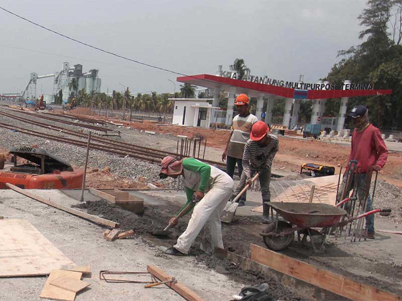  Pekerja menyelesaikan pembangunan stasiun dan jalur kereta api di kawasan Pelabuhan Kuala Tanjung Kabupaten Batubara, Sumatera Utara, Jumat (27/7). 