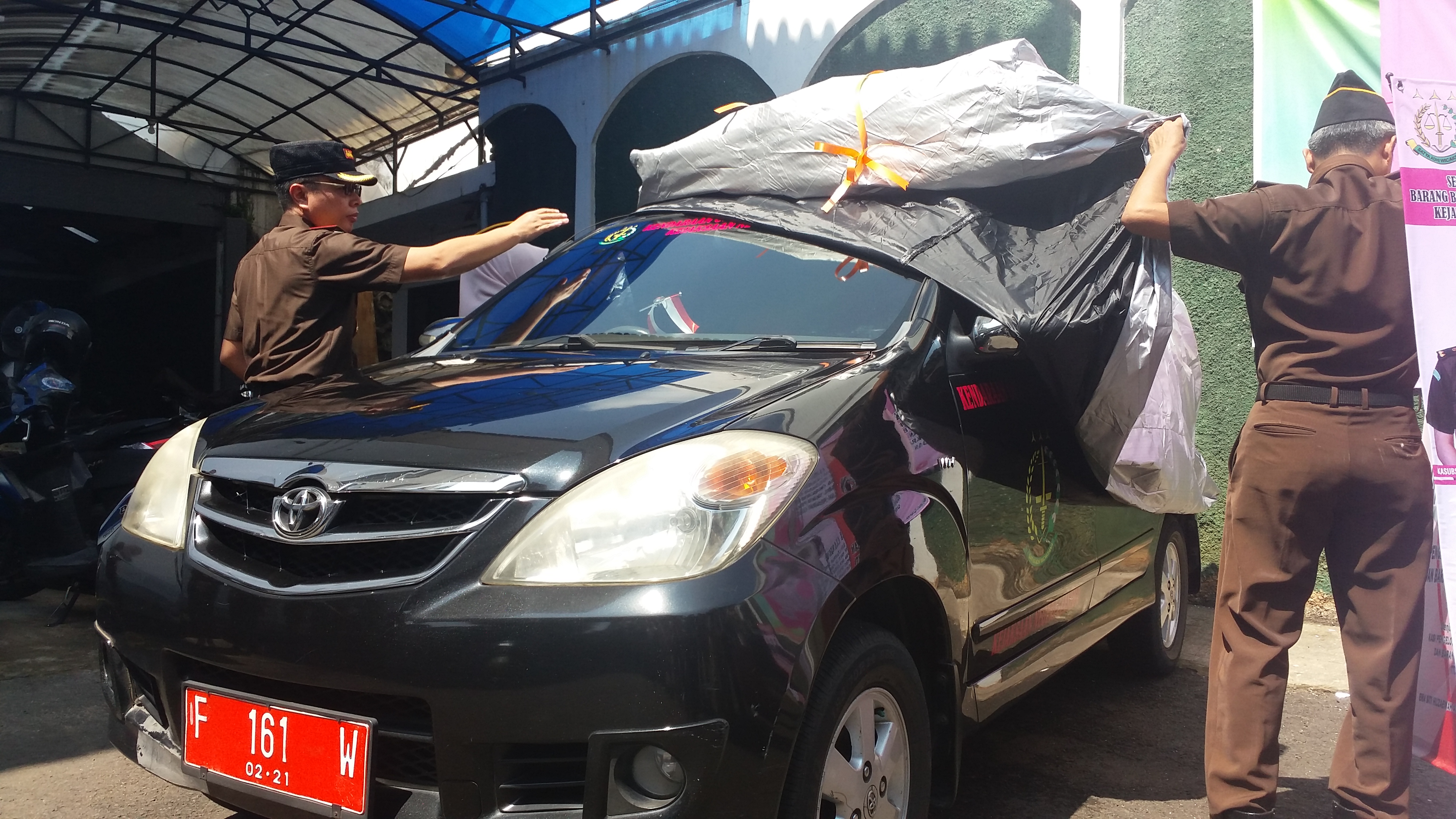 Kepala Kejari Cianjur, Jawa Barat, Yudhi Sufriadi (kiri), menggunting pita tanda diluncurkannya kendaraan operasional dalam program layanan pengembalian dan penitipan barang bukti secara daring di halaman Kejari Cianjur, Senin (25/2).