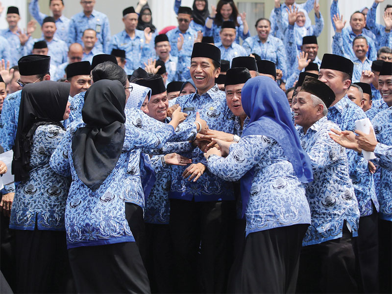 Para peserta Rakernas Korps Pegawai Republik Indonesia (Korpri) 2019 berebut bersalaman dengan Presiden Joko Widodo seusai foto bersama di halaman Istana Merdeka, Jakarta