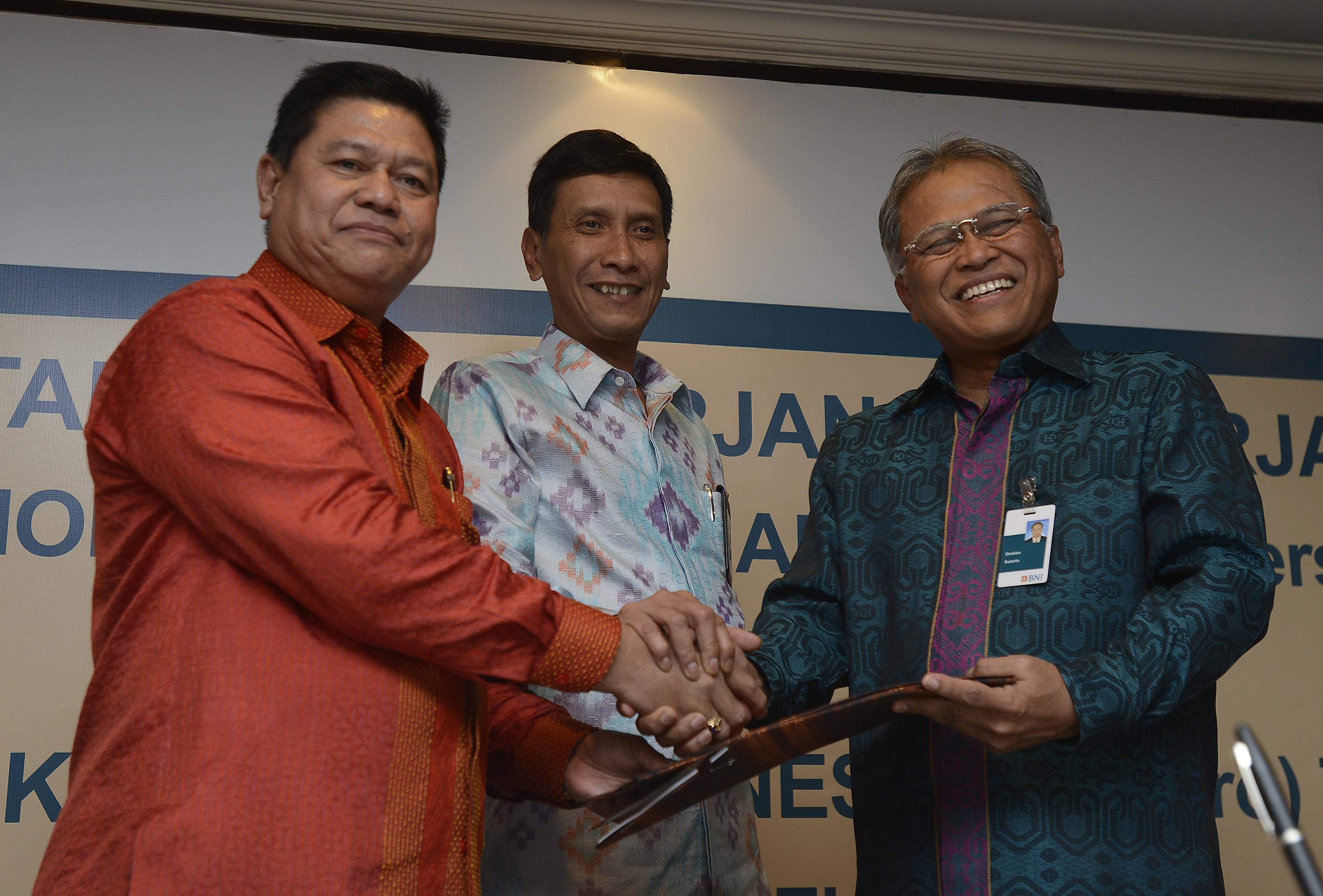 : Direktur Bisnis Banking II BNI Sutanto (kanan), Direktur Keuangan dan Operasi PNM Kemas Hasani (kiri) dan Direktur Bisnis Banking I BNI Herry Sidharta (tengah) berjabat tangan bersama seusai penandatanganan kerjasama di Jakarta