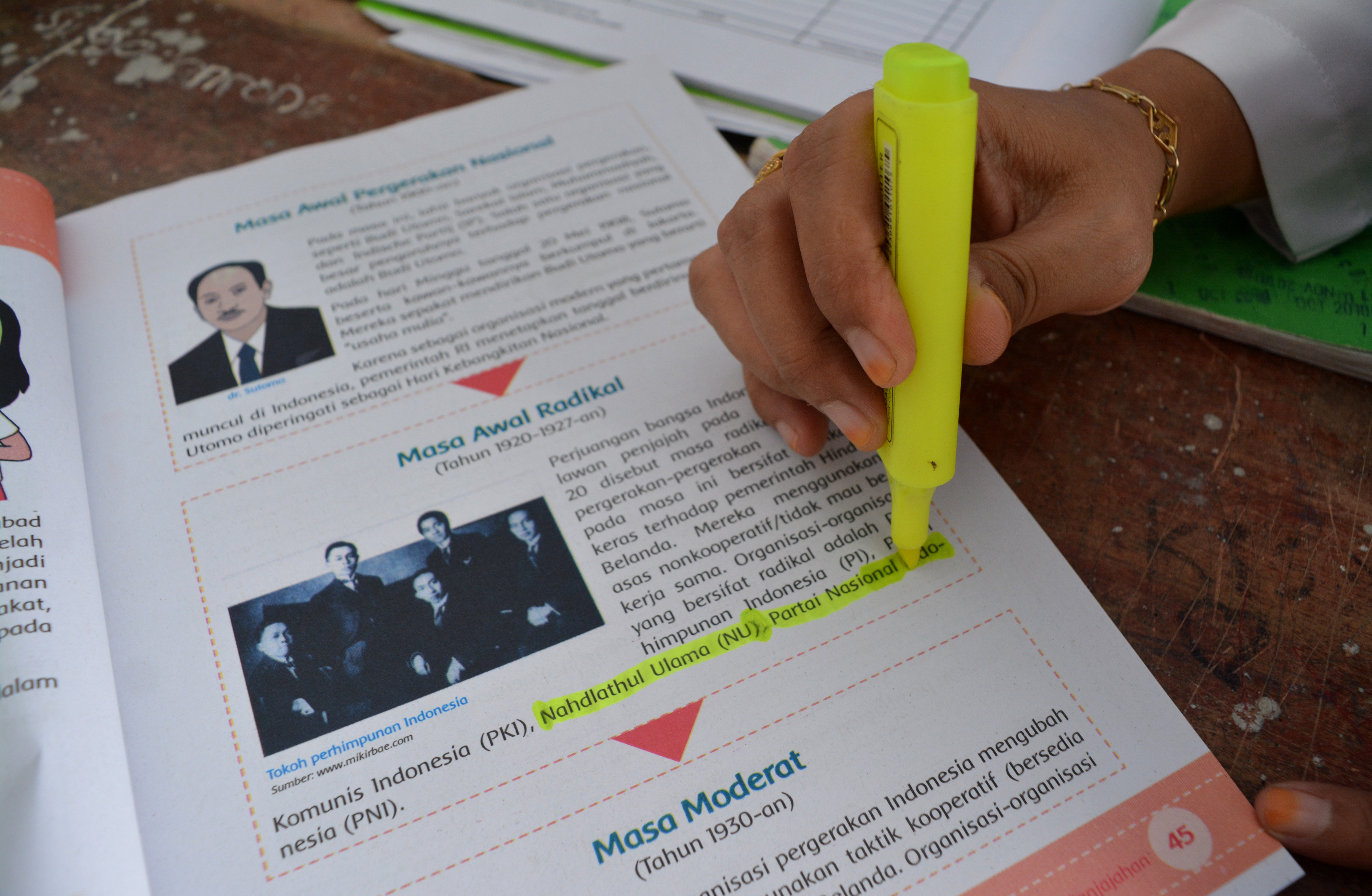 Guru Madrasah Ibtidaiyah (MI) Sulamuddiniyah menunjukkan buku panduan belajar untuk kelas V SD/MI di Gondek, Kecamatan Mojowarno, Jombang, Jawa Timur