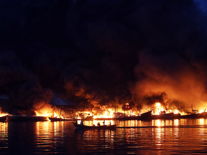 KEBAKARAN KAPAL DI PELABUHAN MUARA BARU: Warga melihat kapal-kapal nelayan terbakar di Pelabuhan Muara Baru, Jakarta, Sabtu (23/2/2019).