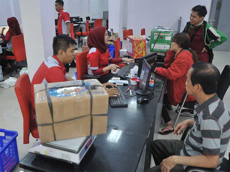 Petugas ekspedisi melayani pengiriman paket pelanggan di salah satu Kantor Cabang ekspedisi di Palembang, Rabu (30/1/2019).