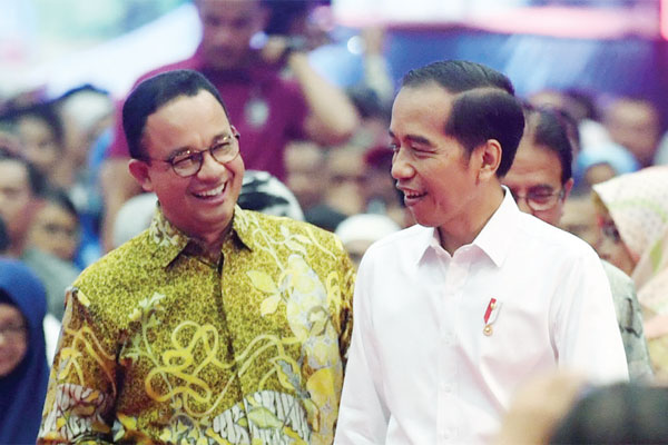 Presiden Joko Widodo berbincang dengan Gubernur DKI Jakarta Anies Baswedan (kiri) di sela acara penyerahan sertifi kat tanah untuk rakyat di Gelanggang Remaja Pasar Minggu, Jakarta, kemarin. Dalam kesempatan itu Presiden membagikan 3.000 sertifi kat tanah 