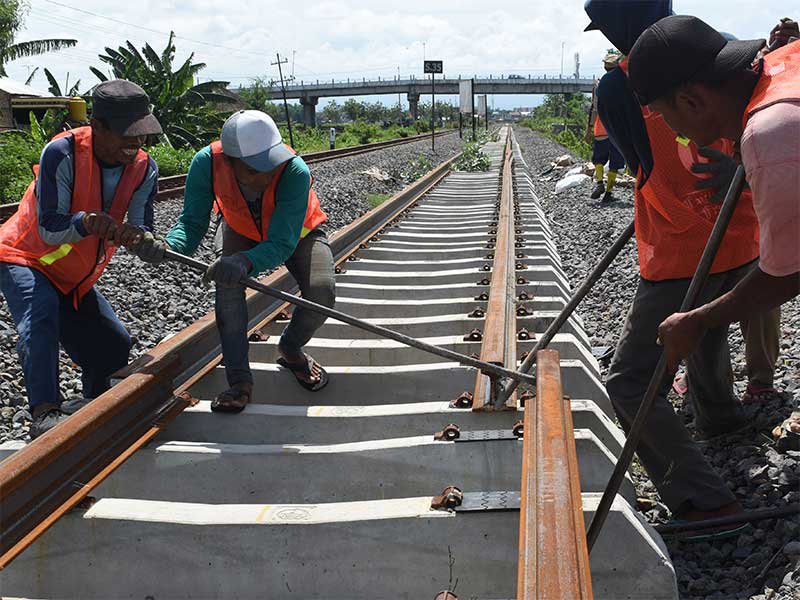 Pekerja memasang rel Kereta Api (KA) yang merupakan bagian dari pembangunan jalur ganda KA lintas selatan di Kota Madiun, Jawa Timur, Rabu (28/11/2018). 