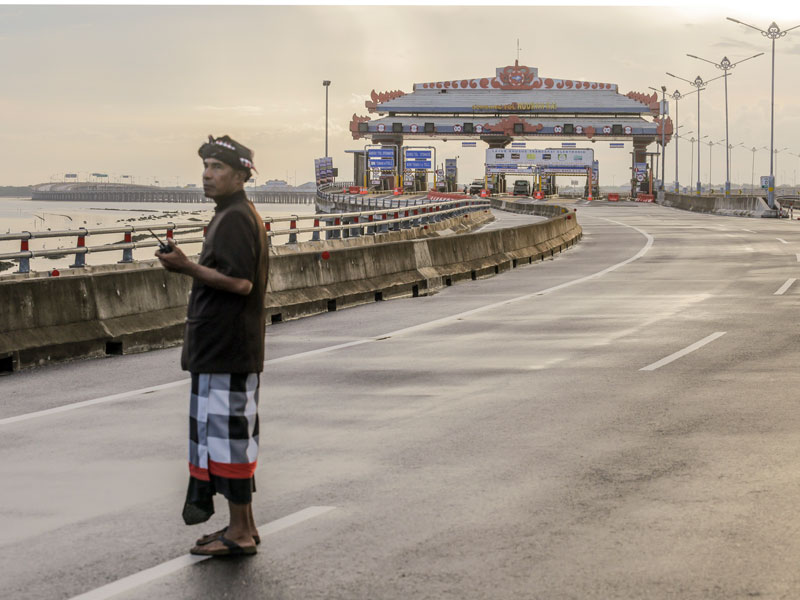 Seorang petugas keamanan adat Bali atau Pecalang berpatroli di jalan tol Bali Mandara saat Hari Raya Nyepi.