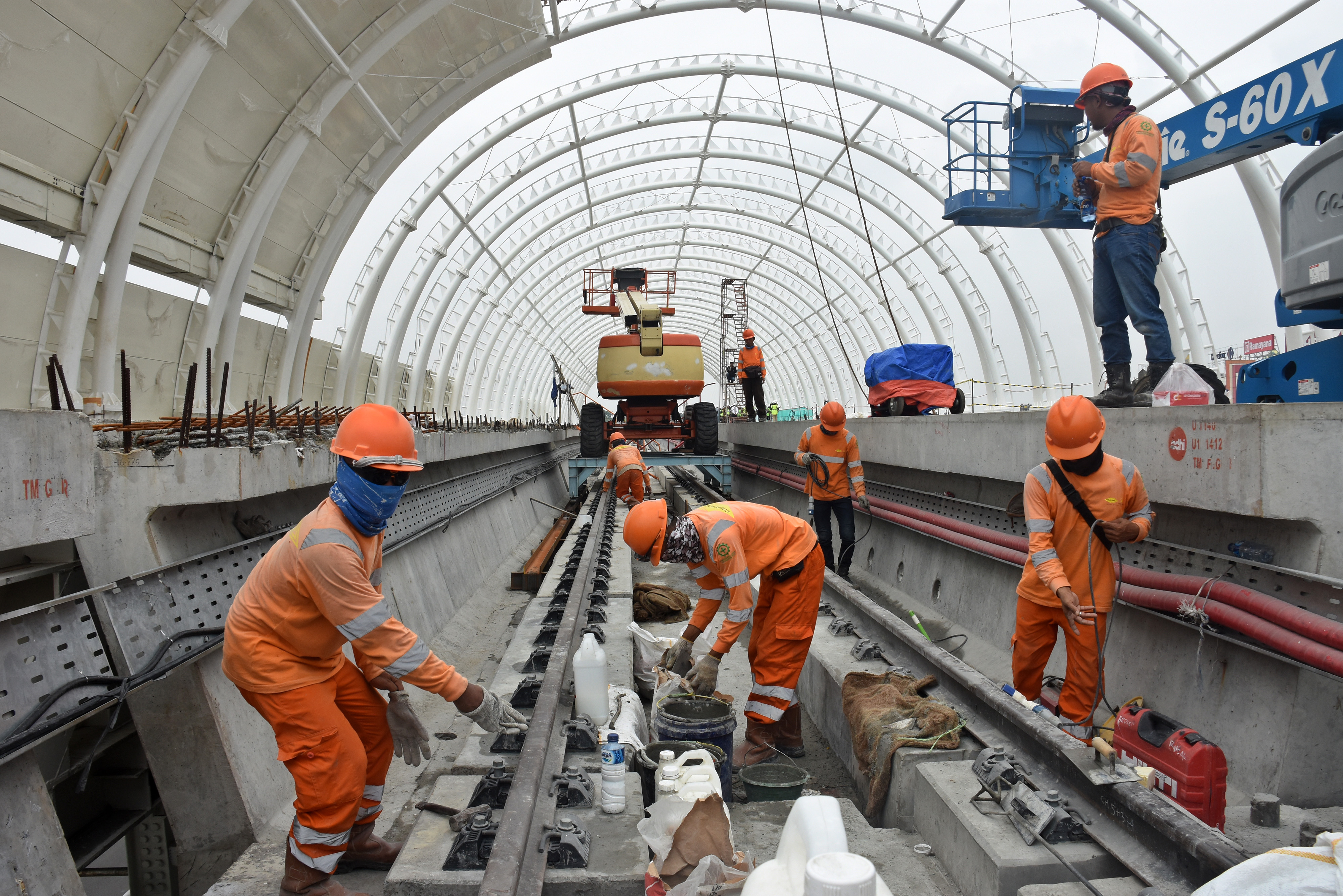  PROGRES PEMBANGUNAN LRT JABODEBEK: Pekerja menyelesaikan pembangunan stasiun kereta api ringan atau Light Rail Transit (LRT) Taman Mini, di Jakarta