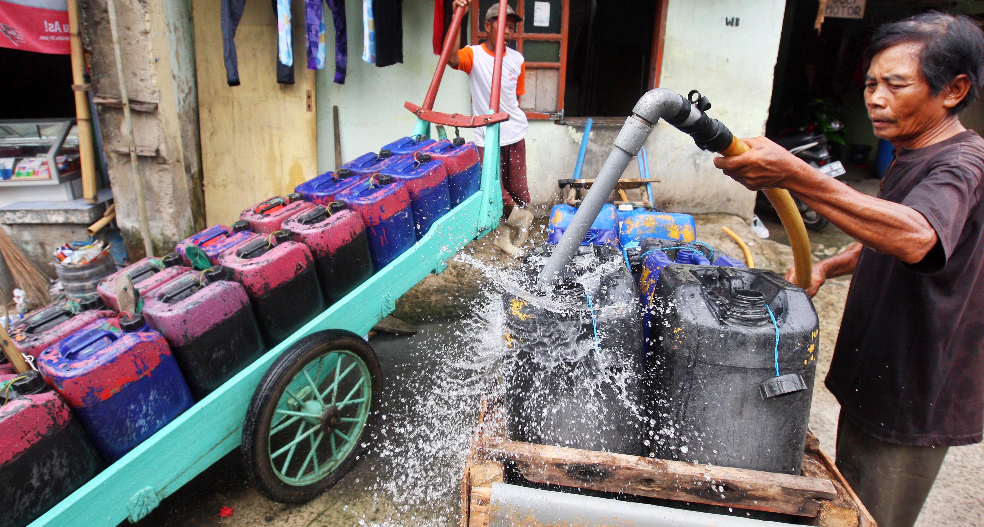  AIR BERSIH UNTUK JAKARTA: Penjual air keliling mengisi air bersih kedalam drigen untuk disalurkan kepada langganannya di kawasan Penjaringan, Jakarta Utara, Kamis (11/4). Jokowi berencana menyudahi kontrak dengan perusahaan air minum PT PAM Lyonnaise Jaya