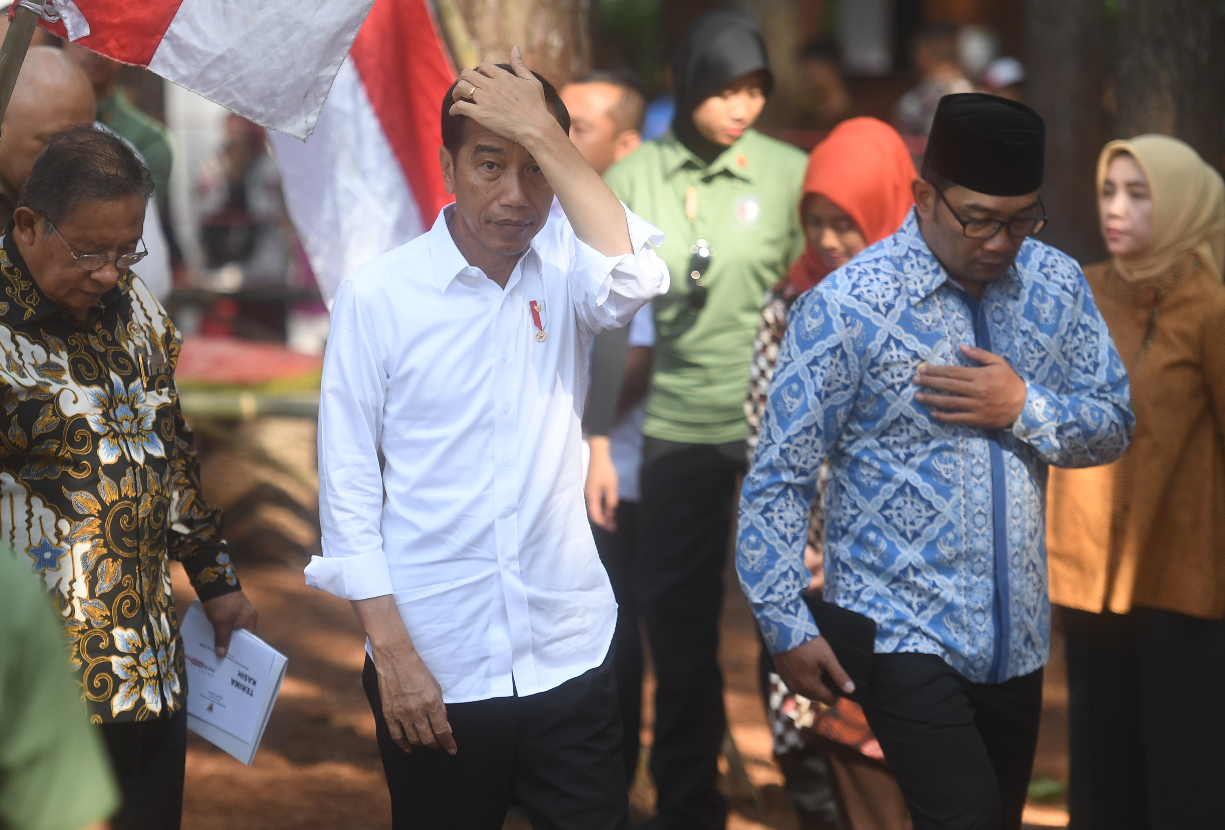  Presiden Joko Widodo (tengah) didampingi Gubernur Jawa Barat Ridwan Kamil (kanan) dan Menko Perekonomian Darmin Nasution (kiri) tiba di lokasi pembagian Surat Keputusan tentang Pengelolaan Hutan Sosial di Wana Wisata Pokland Haurwangi, Cianjur